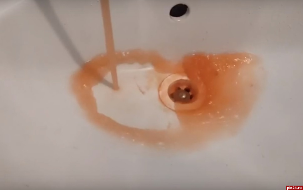 Вода кирпичного цвета течет из крана в одном из домов в псковской Тямше